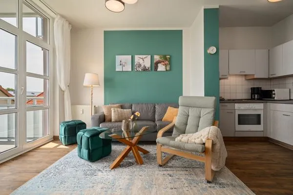 Ferienwohnung Hafenkino Waren (Müritz) - offener Wohnbereich mit einladener Couch  Hafenkino