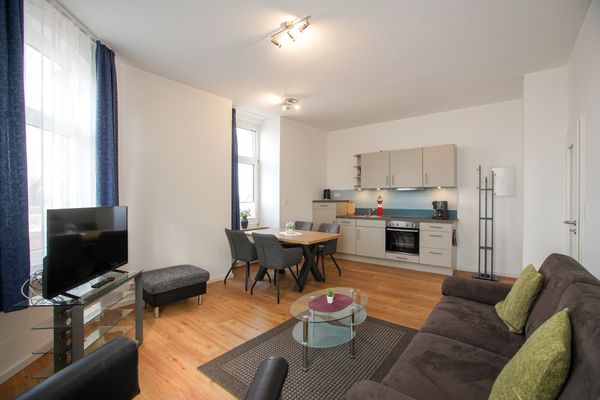  Haus Derk Juist - Wohnung 7 Borkum - Blick vom Sofa Richtung Esstisch mit vier Stühlen und Küchenzeile