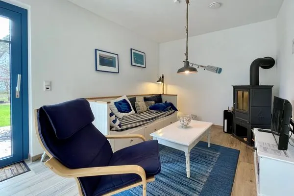 Entspannen Sie in diesem stilvollen Wohnzimmer mit Kamin und bequemem Sofa.  Haus Schiffchen