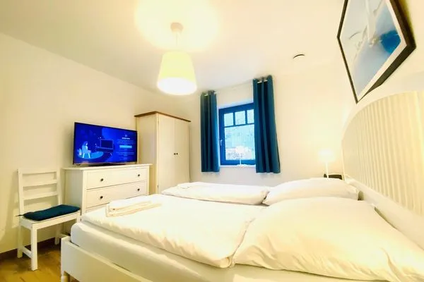 Gemütliches Schlafzimmer mit Fernseher und modernem Design für erholsame Nächte.  Haus Schiffchen