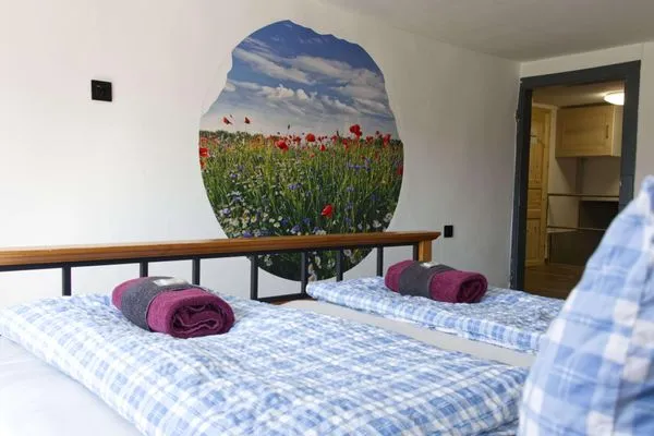 2. Schlafzimmer ab der 3. Person verfügbar - Blick über das Bett mit dekorativen Wandbild  Ferienapartment Zur guten Quelle