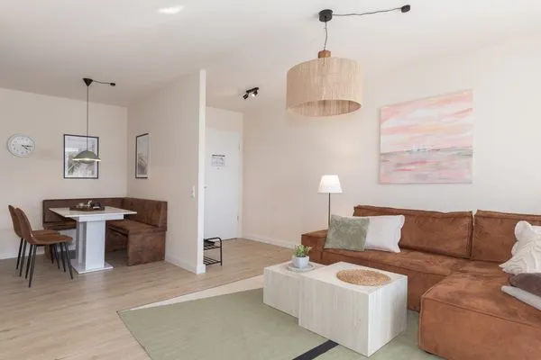 Ferienwohnung Küstenglück Aparthotel Zingst - Wohnzimmer mit Blick zur offenen Wohnküche  Küstenglück