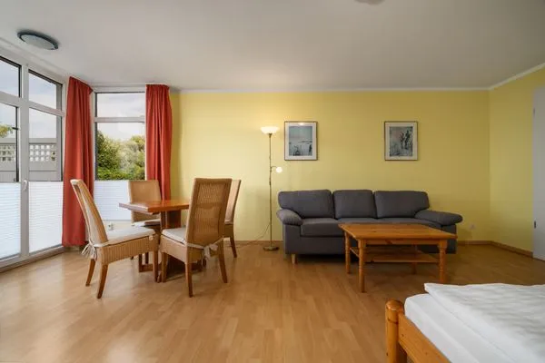 Ferienwohnung Abendsonne Waren - offener Wohnbereich mit gemütlichem schwarzen Sofa  Abendsonne