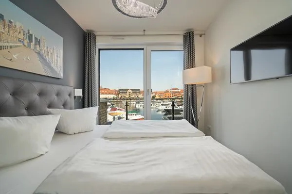Ferienwohnung First Marina View Waren (Müritz) - Schlafzimmer mit Hafenblick und TV  First Marina View