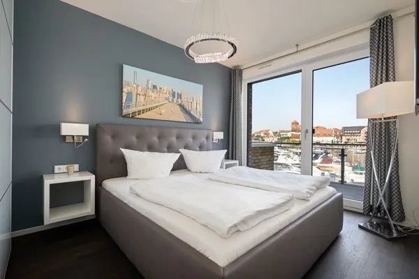 Ferienwohnung First Marina View Waren (Müritz) - Schlafzimmer mit Boxspringbett und Hafenblick  First Marina View