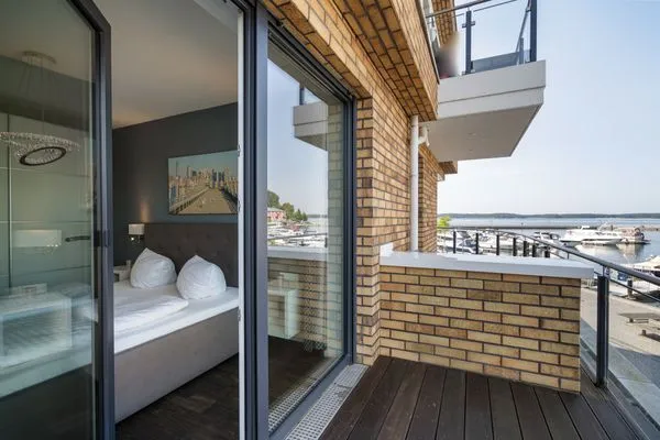 Ferienwohnung First Marina View Waren (Müritz) - Schlafzimmer mit Zugang zum Balkon und traumhaftem Hafenblick  First Marina View