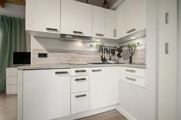 Ferienhaus Kleine Sommerliebe Waren (Müritz) - Stilvolle Küchenzeile in Weiß mit Arbeitsfläche und Kochutensilien  Kleine Sommerliebe