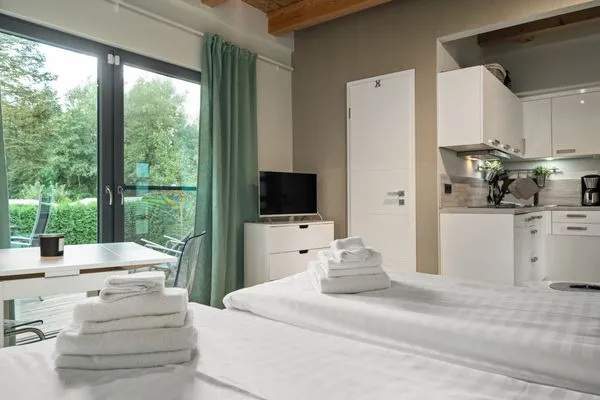 Ferienhaus Kleine Sommerliebe Waren (Müritz) - Schlafzimmer mit Doppelbett, Küchenzeile und Zugang zur Terrasse  Kleine Sommerliebe