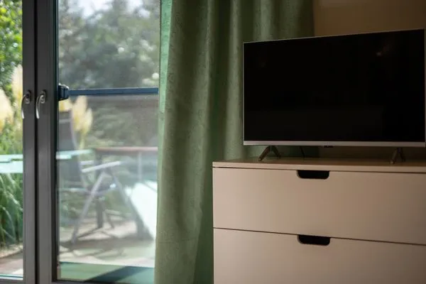 Ferienhaus Kleine Sommerliebe Waren (Müritz) - TV-Bereich mit Kommode und Blick auf die Terrasse  Kleine Sommerliebe