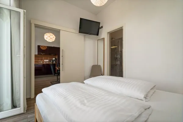 Ferienwohnung Altstadtapartment Carli Waren (Müritz) - Schlafzimmer mit Doppelbett, TV und Zugang zum Bad  Altstadtapartment Carli