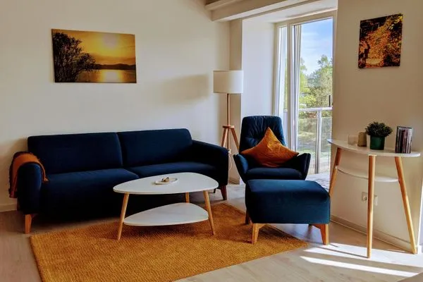 Wohn/Essbereich: Sofa, Sessel, TV, Zugang zum Balkon  FeWo room-of-light in PRORA - 9.34