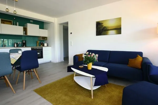 Wohn/Essbereich: Sofa, Sessel, TV, Zugang zum Balkon  FeWo room-of-light in PRORA - 9.34