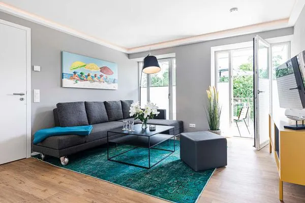 Wohnzimmer: Schlafsofa, Sitzhocker, TV, Zugang zum Balkon  FeWo Wunderschön! in PRORA - 8.21