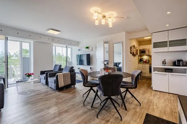 Wohn/Essbereich: Sofa, Sitzbereich, Essbereich, TV, Zugang zum Balkon  FeWo Auszeit in PRORA - 9.42