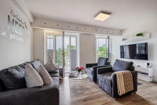 Wohn/Essbereich: Sofa, Sitzbereich, Essbereich, TV, Zugang zum Balkon  FeWo Auszeit in PRORA - 9.42