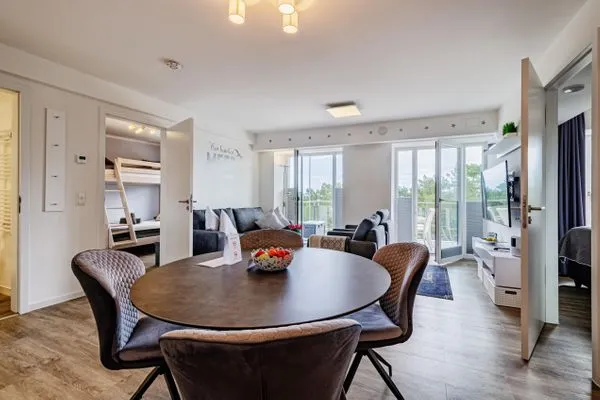 Wohn/Essbereich: Sofa, Sitzbereich, Essbereich, TV, Zugang zum Balkon  FeWo Auszeit in PRORA - 9.42