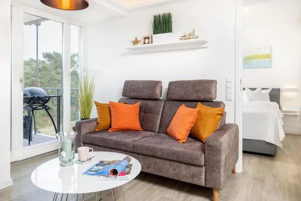 Wohn/Essbereich: Sofa, Essbereich, TV, Zugang zum Balkon  FeWo Dünenblick in PRORA - 5.34