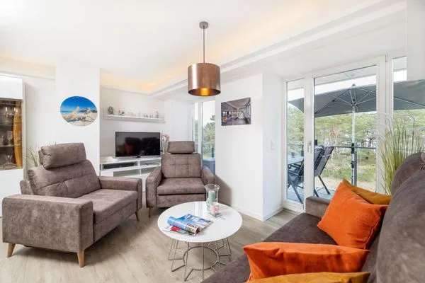 Wohn/Essbereich: Sofa, Essbereich, TV, Zugang zum Balkon  FeWo Dünenblick in PRORA - 5.34