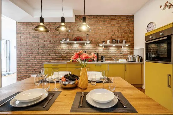 Offener Wohnbereich mit Zugang zur Terrasse, integrierter Küche, Esstisch, ausziehbarer Couch, Relaxsesseln, Smart-TV  FeWo Dünenterrasse in PRORA - 9.04