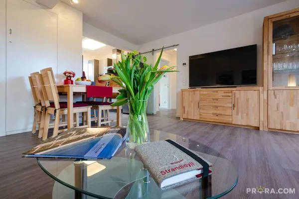 Wohn/Essbereich: Couch und Sessel, TV, Zugang zum Balkon  FeWo Strandidyll in PRORA - 9.31