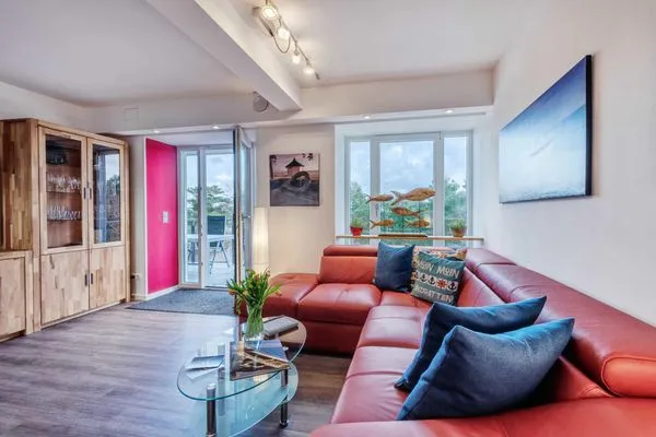 Wohn/Essbereich: Couch und Sessel, TV, Zugang zum Balkon  FeWo Strandidyll in PRORA - 9.31