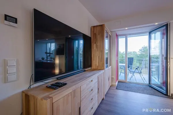 Wohn/Essbereich: Couch und Sessel, TV, Zugang zum Balkon  FeWo Strandidyll in PRORA - 9.31