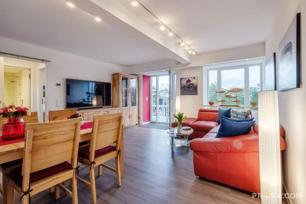 Wohn/Essbereich: Couch und Sessel, TV, Zugang zum Balkon  FeWo Strandidyll in PRORA - 9.31