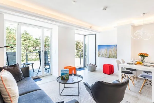 Wohn/Essbereich: Sofa, Sessel, TV, Zugang zum Balkon  FeWo MariSol in PRORA Strandnah mit Meerblick & Sauna - 5.22