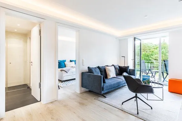 Wohn/Essbereich: Sofa, Sessel, TV, Zugang zum Balkon  FeWo MariSol in PRORA Strandnah mit Meerblick & Sauna - 5.22