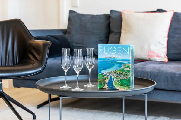 Wohn/Essbereich: Sofa, Sessel, TV, Zugang zum Balkon  FeWo MariSol in PRORA Strandnah mit Meerblick & Sauna - 5.22