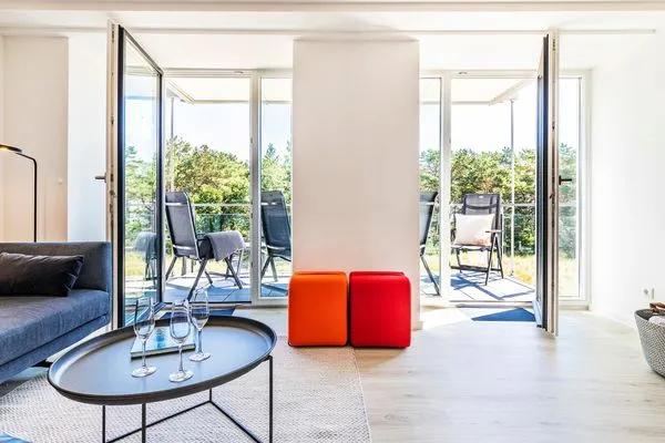 Wohn/Essbereich: Sofa, Sessel, TV, Zugang zum Balkon  FeWo MariSol in PRORA Strandnah mit Meerblick & Sauna - 5.22