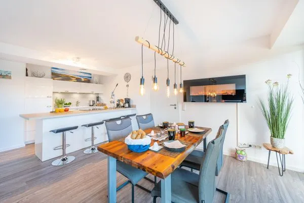 Wohn/Essbereich: Sofa, Sitzbereich, Essbereich, TV, Elektrokamin, Zugang zum Balkon  FeWo Meerlust in PRORA - 4.42