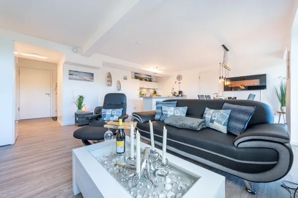 Wohn/Essbereich: Sofa, Sitzbereich, Essbereich, TV, Elektrokamin, Zugang zum Balkon  FeWo Meerlust in PRORA - 4.42