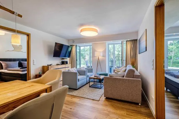 Wohnzimmer: Schlafcouch für 2 Pers., Smart-TV 55 Zoll, Essbereich, Zugang zum Balkon  FeWo Moin in PRORA - 9.12