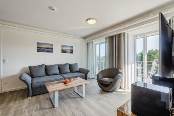 Wohnzimmer: Schlafsofa, TV, Zugang zum Balkon  FeWo Ostwind in PRORA - 5.43