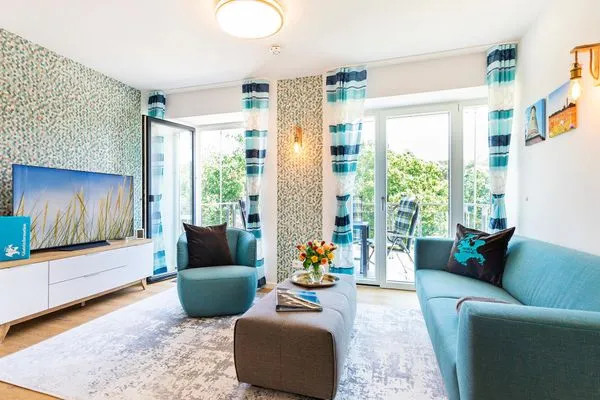 Wohn-/Essbereich: Sitzgruppe mit Couch und Sessel, Smart-TV, Zugang zum Balkon, Esstisch mit 5 Stühlen  FeWo PRORA week in PRORA - 2.22