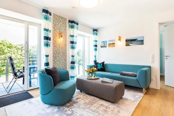 Wohn-/Essbereich: Sitzgruppe mit Couch und Sessel, Smart-TV, Zugang zum Balkon, Esstisch mit 5 Stühlen  FeWo PRORA week in PRORA - 2.22