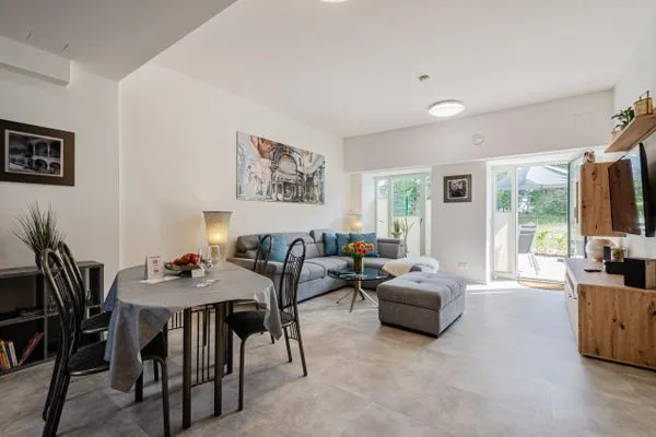 Wohnzimmer: Schlafsofa und Sessel, TV, Essbereich, Zugang zur Terrasse  FeWo Proras Strandhaus in PRORA - 9.03