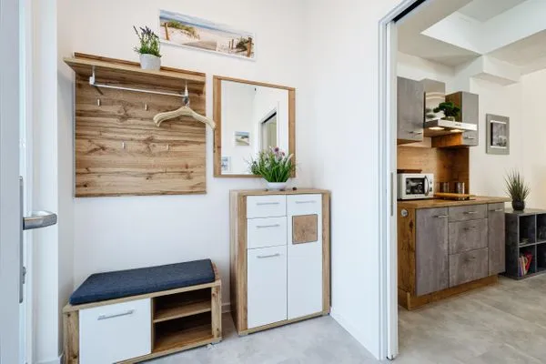 Wohnzimmer: Schlafsofa und Sessel, TV, Essbereich, Zugang zur Terrasse  FeWo Proras Strandhaus in PRORA - 9.03