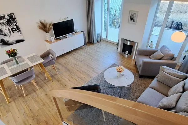 Wohnzimmer: Sitzecke, TV, Essbereich, Zugang zur Terrasse  FeWo Seaside in PRORA Maisonette mit Terrasse, Waschmaschine & E-Ladesäule - 9.06