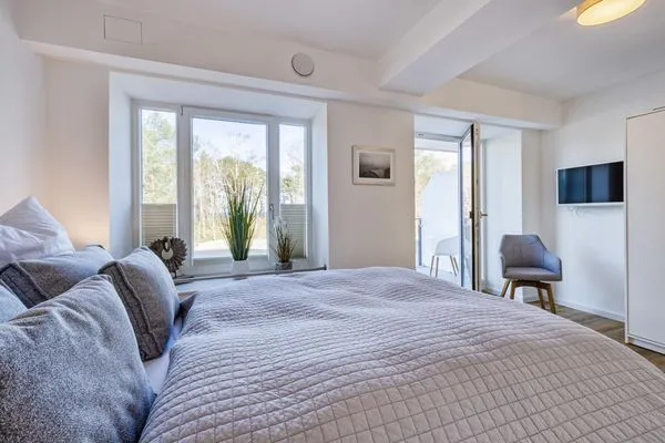 Schlafzimmer 1: Doppelbett (160 x 200), TV, Kleiderschrank, Zugang zum Balkon  FeWo Seaside in PRORA Maisonette mit Terrasse, Waschmaschine & E-Ladesäule - 9.06