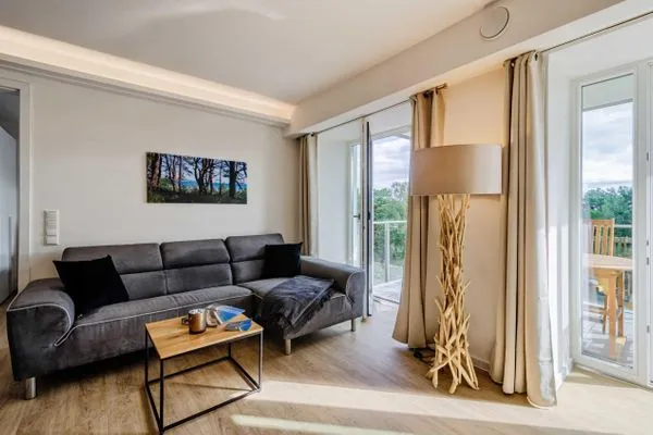 Wohnzimmer: Sofa, TV, Zugang zum Balkon  FeWo Se(e)hnsucht in PRORA - 9.32