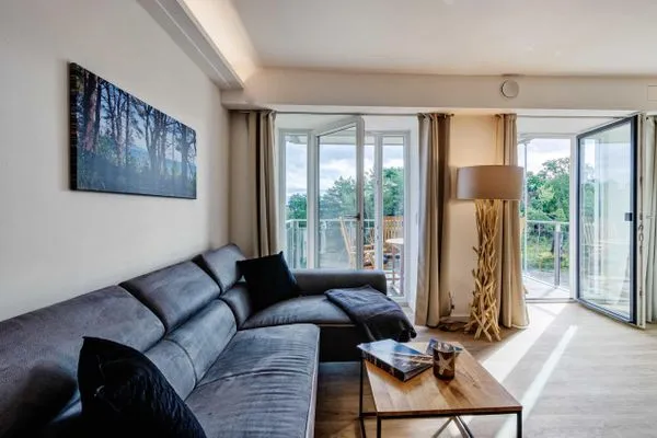 Wohnzimmer: Sofa, TV, Zugang zum Balkon  FeWo Se(e)hnsucht in PRORA - 9.32