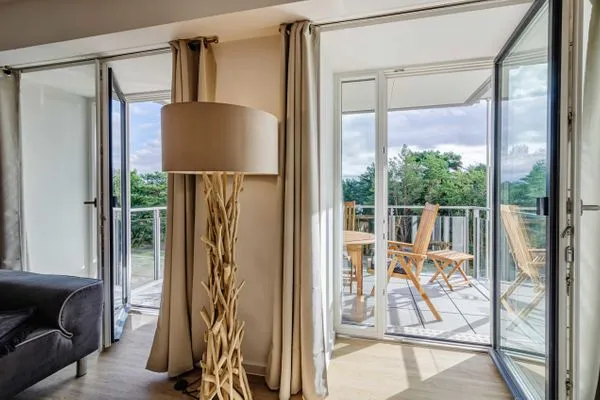 Wohnzimmer: Sofa, TV, Zugang zum Balkon  FeWo Se(e)hnsucht in PRORA - 9.32