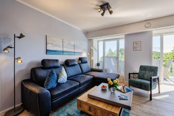 Wohnzimmer: Sofa, TV, Essbereich, Zugang zum Balkon  FeWo Strandglück in PRORA - 9.44