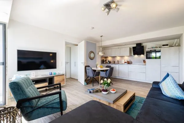 Wohnzimmer: Sofa, TV, Essbereich, Zugang zum Balkon  FeWo Strandglück in PRORA - 9.44