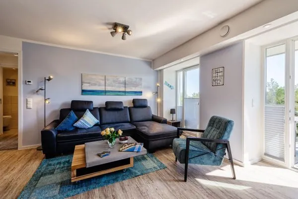 Wohnzimmer: Sofa, TV, Essbereich, Zugang zum Balkon  FeWo Strandglück in PRORA - 9.44