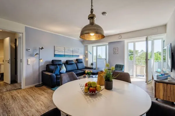 Wohnzimmer: Sofa, TV, Essbereich, Zugang zum Balkon  FeWo Strandglück in PRORA - 9.44