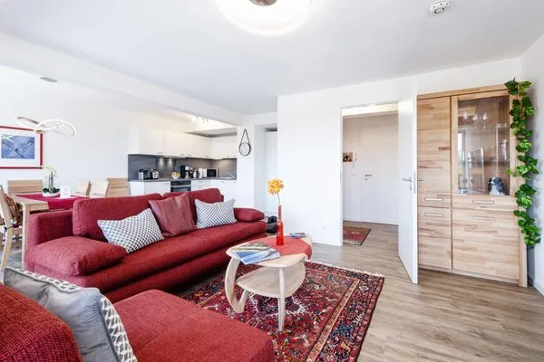 Wohnzimmer: Schlafsofa und Sessel, TV, Essbereich, Zugang zum Balkon  FeWo Seemelodie in PRORA - 9.43