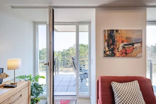 Wohnzimmer: Schlafsofa und Sessel, TV, Essbereich, Zugang zum Balkon  FeWo Seemelodie in PRORA - 9.43